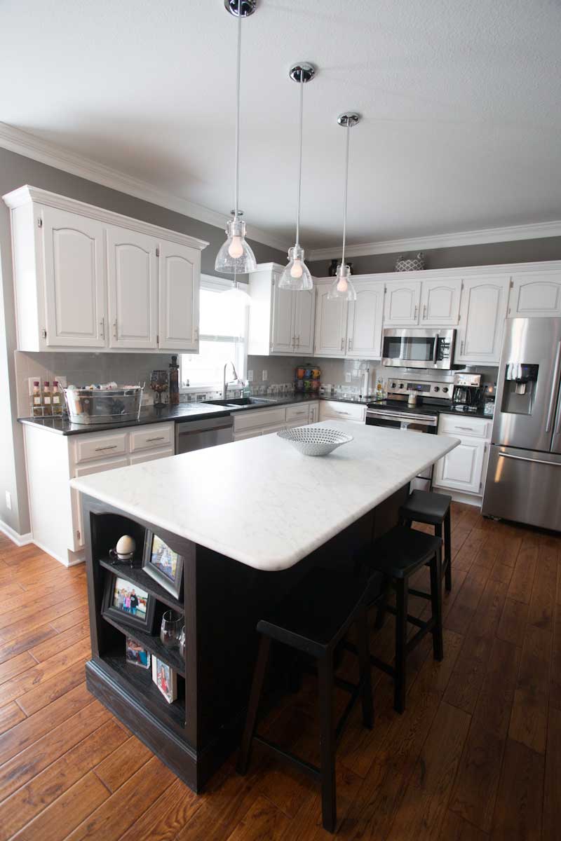 kitchen remodel-marble island countertop-white cabinets-pendant lights