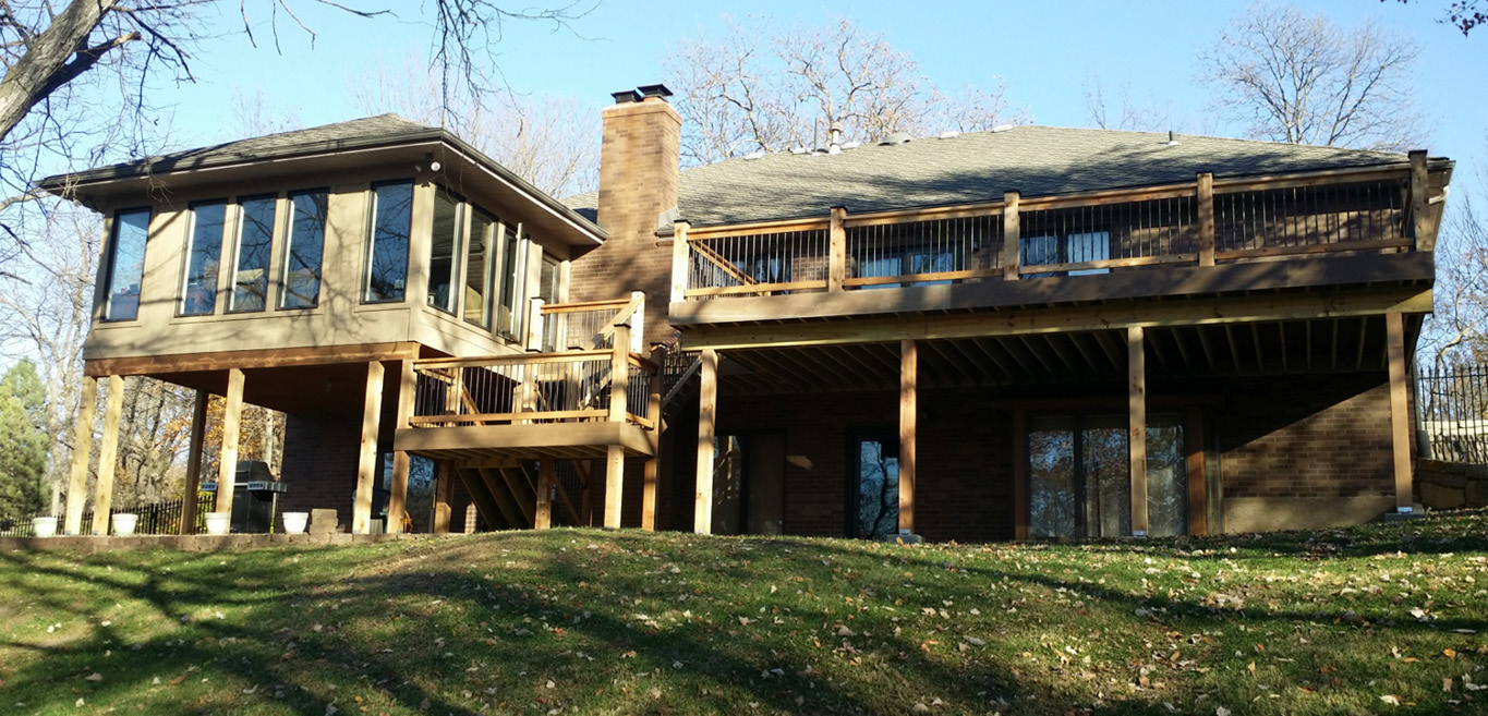 Large backyard deck with sunroom spanning the length of the house