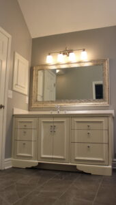 Custom bathroom vanity with wood cabinetry, stone countertop, and integrated sink installed during a Kansas City bathroom remodeling project.