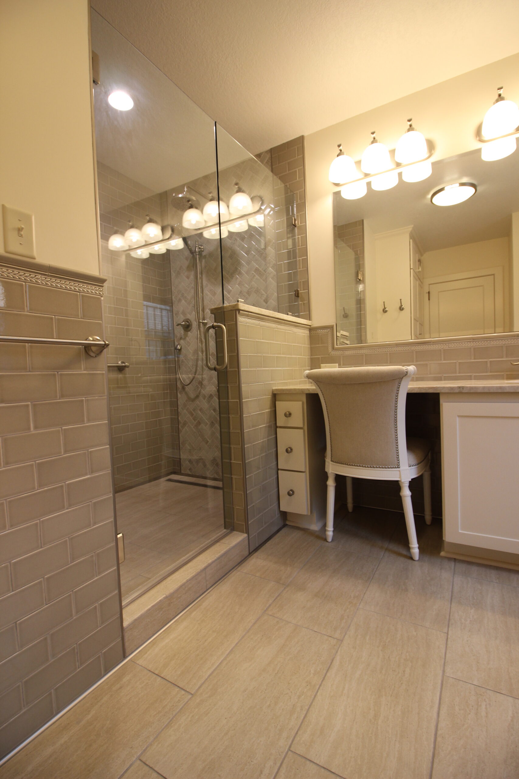 Luxury master bathroom featuring a large custom vanity, quartz countertops, handcrafted tile, frameless glass shower doors, and a walk-in shower during a Kansas City bathroom remodeling project.